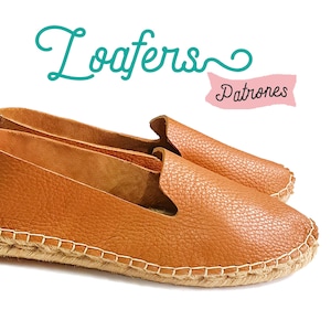 Könnte beinhalten: Ein Paar braune Leder-Slipper mit einer Kordelsohle. Die Slipper haben ein schlichtes Design und sind perfekt für Freizeitkleidung.