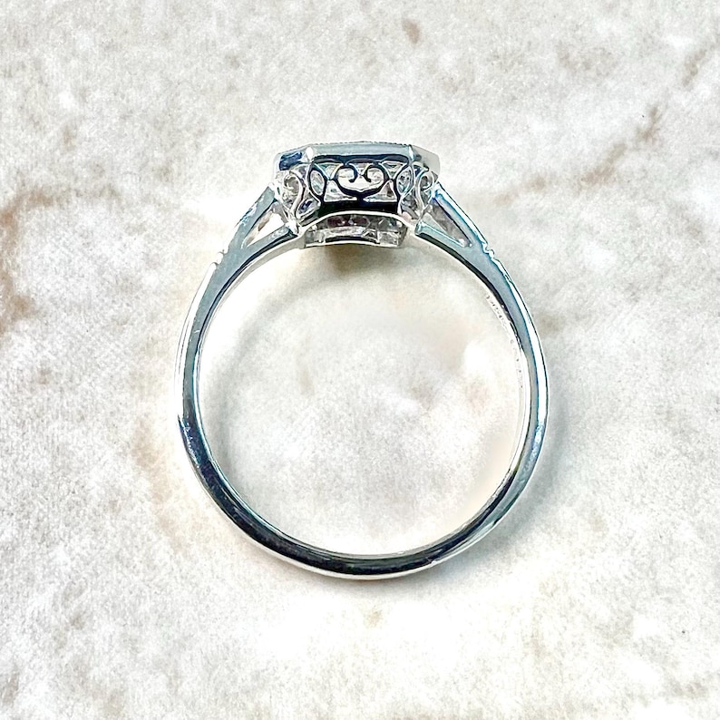 May include: A silver ring with a large, octagonal-shaped gemstone set in a filigree design.