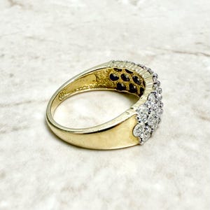 May include: A gold band ring with a row of small, clear diamonds set in a pave setting.