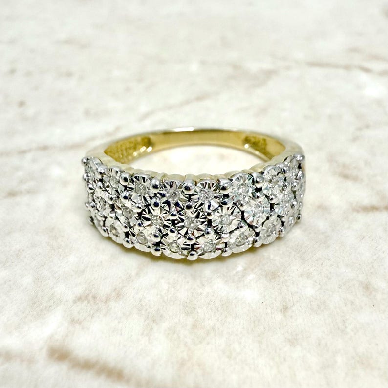 May include: A gold band ring with a row of small diamonds set in a pave setting.