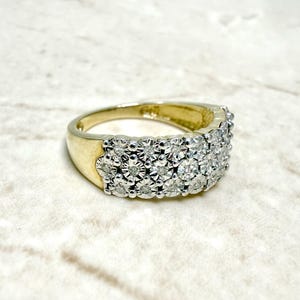 May include: A gold band ring with a row of small, round diamonds set in a pave setting.