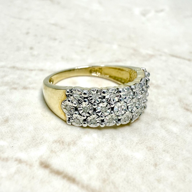 May include: A gold band ring with a row of small, round diamonds set in a pave setting.