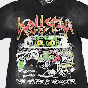 Könnte beinhalten: Ein schwarzes Kurzarm-T-Shirt mit einem Grafikdruck eines Autoinnenraums und einer Kreatur mit grünen Augen im Rückspiegel. Der Text lautet HELLSTAR, RIDE THE LIGHTNING und THE FUTURE IS HELLSTAR in weißer, gelber und rosa Schrift.