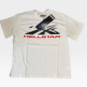Könnte beinhalten: Ein weißes Kurzarm-T-Shirt mit einem schwarzen Grafikdesign auf der Brust und dem Wort HELLSTAR in roter Schrift. Ein schwarzes, rechteckiges Markenetikett ist am Halsausschnitt befestigt und zeigt das HELLSTAR-Logo sowie eine kreisförmige Grafik.