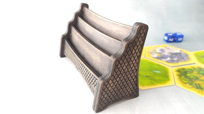 May include: A wooden card holder with three slots, featuring a decorative dragon scale pattern on the side. The holder is stained a dark brown color.