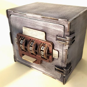 May include: A small wooden box with a combination lock. The box is painted a light gray color and has a distressed finish. The lock has three dials with numbers 1-9.