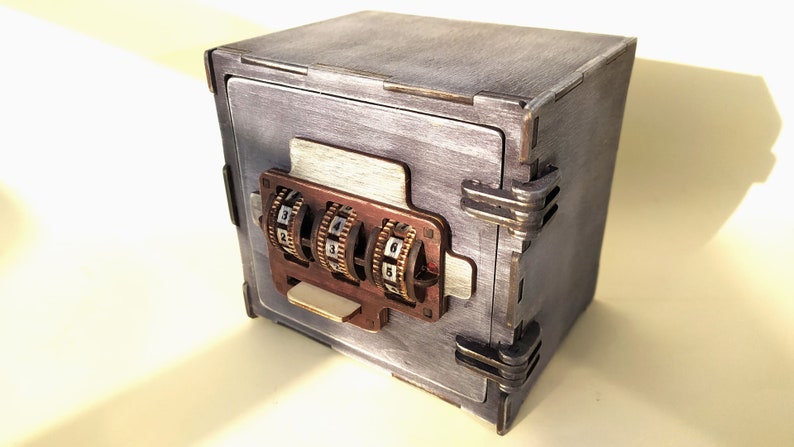 May include: A small wooden box with a combination lock. The box is painted a light gray color and has a distressed finish. The lock has three dials with numbers 1-9.