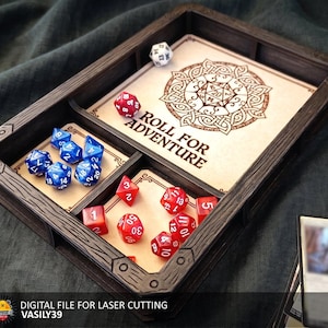 May include: A rectangular dark wood dice tray with three internal compartments. The largest section features a laser-engraved circular design and the text "ROLL FOR ADVENTURE." The tray contains several blue and red multi-sided gaming dice.