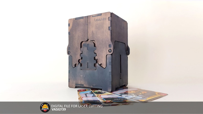 May include: A wooden box with a dark brown stain and a black interior. The box is designed to hold cards and has a slot for the cards to be inserted. The box is labeled "VASILY39" and is a digital file for laser cutting.