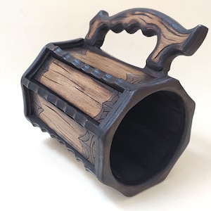 May include: A wooden beer stein with a dark brown finish and a carved wooden handle. The stein has a hexagonal shape and is decorated with a wood grain pattern.