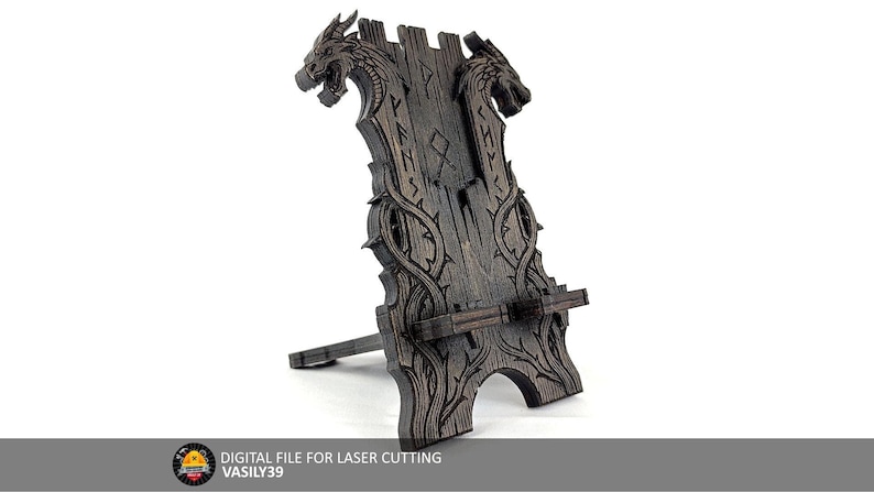 May include: A dark brown wooden phone or tablet stand with dragon head carvings at the top. The stand has a decorative design with runes and vines. The base is angled for optimal viewing. The text "DIGITAL FILE FOR LASER CUTTING" is at the bottom.