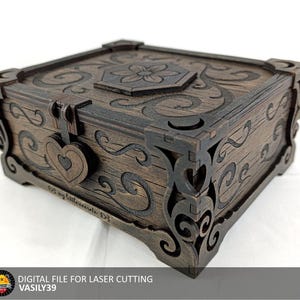 Puede incluir: Una caja de madera marrón oscuro con intrincados diseños cortados con láser. La caja presenta un cierre en forma de corazón, patrones florales y de volutas, y detalles decorativos en las esquinas. La tapa tiene un diseño floral. Archivo digital para corte láser.