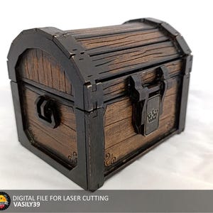 Peut inclure: Un coffre au trésor en bois avec un cadre et des charnières en métal noir. Le coffre a une serrure avec un motif de couronne et une poignée sur le côté.
