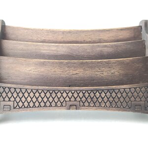 May include: A wooden letter holder with three tiers and a decorative bottom. The holder is dark brown and has a distressed finish.
