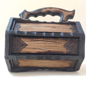 May include: A wooden box with a carved handle and intricate designs. The box is made of dark wood with a light wood interior.
