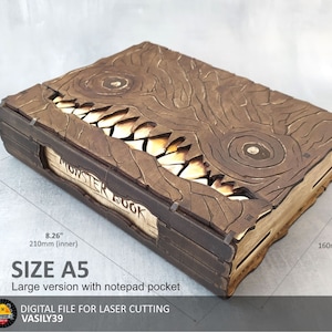 May include: A brown wooden box shaped like a book with a monster face on the front. The box is labelled "Monster Book" and has a notepad pocket. The box is 210mm wide, 160mm tall, and 40mm deep.