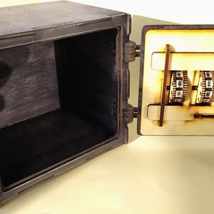 May include: A wooden box with a combination lock on the door. The door is open and the lock is visible. The box is painted black and the lock is made of wood.