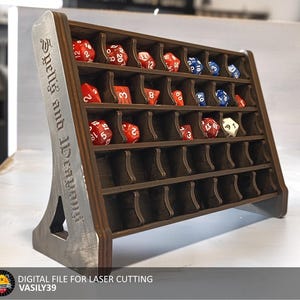 以下が含まれることがあります： サイコロを収納するための36個のコンパートメントが付いた木製サイコロタワー。タワーには「Spells and Treasures」とラベルが貼られており、スタンドが付いています。