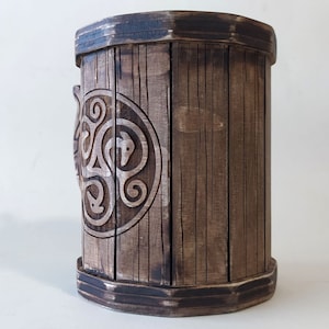 May include: A wooden mug with a Celtic knot design carved into the side. The mug is brown and has a dark brown rim.