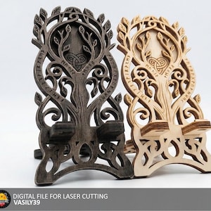 Puede incluir: Dos soportes de teléfono de madera tallados intrincadamente. Uno es marrón oscuro, el otro es marrón claro. Ambos presentan un diseño de árbol con detalles de nudos celtas e inscripciones rúnicas. Los soportes están diseñados para corte por láser.