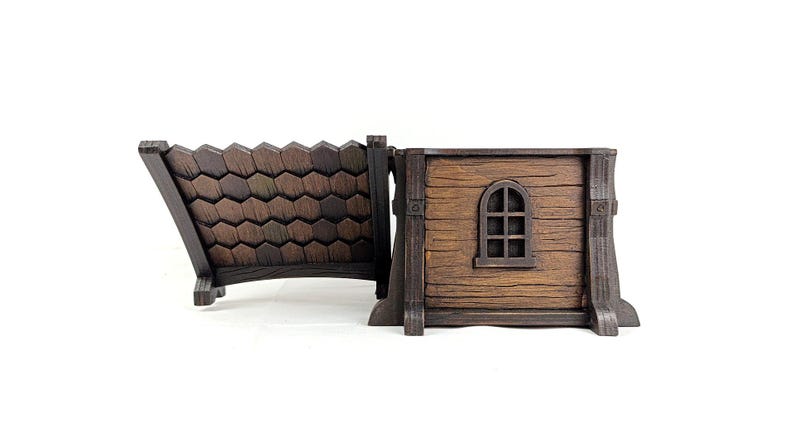 May include: A brown wooden-style box with a hinged lid that features a textured shingle pattern. The main body of the box has a horizontal wood grain texture and a small, arched window frame detail on the side, finished in dark brown tones.