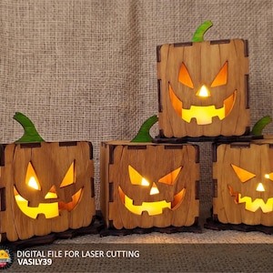 Puede incluir: Cuatro cajas cuadradas de madera con forma de calabaza de Halloween con caras cortadas a láser, cada una con un tallo verde y una luz amarilla cálida en el interior. El texto en la parte inferior dice: DIGITAL FILE FOR LASER CUTTING VASILY39.