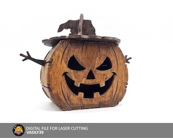 May include: A brown wooden jack-o'-lantern box with a dark brown witch hat lid, featuring cut-out eyes and a wide grinning mouth. The box has small stick-like arms on the sides. Text at the bottom reads: DIGITAL FILE FOR LASER CUTTING VASILY39.