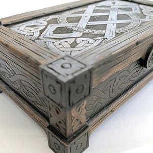 Assembled Celtic style storage box sitting on ancient stone surface.