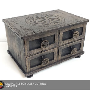 May include: A wooden box with four drawers and a Celtic knot design on the top. The box is dark brown with a distressed finish and has metal accents.