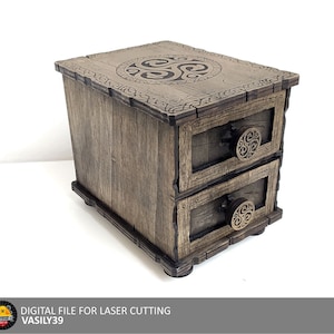 Può includere: Una scatola di legno con due cassetti e un disegno di nodo celtico sulla parte superiore. La scatola è marrone e ha un aspetto rustico.