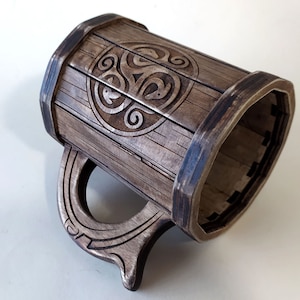 May include: A wooden beer stein with a Celtic knot design. The stein is brown and has a handle.