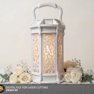 May include: A white, ornate lantern with a handle, featuring intricate cut-out designs. The lantern is surrounded by white roses and other flowers. The text "DIGITAL FILE FOR LASER CUTTING VASILY39" is at the bottom.