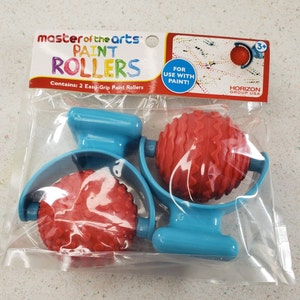 May include: Two blue paint rollers with red textured rollers. The packaging says "master of the arts paint rollers" and "Contains: 2 Easy-Grip Paint Rollers".