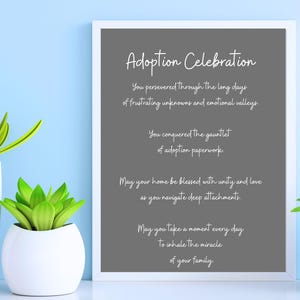 Könnte beinhalten: Ein gerahmter Druck mit grauem Hintergrund und weißem Text, der "Adoption Celebration" lautet. Der Text ist ein Gedicht über die Reise der Adoption, das die Ausdauer, Liebe und Einheit einer Familie feiert.