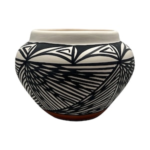 May include: A rounded ceramic pot featuring a matte white rim and a body decorated with intricate black geometric patterns consisting of fine lines and triangles. The base of the vessel is a solid terracotta color, contrasting with the upper design.