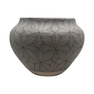 May include: A rounded ceramic vessel featuring a matte off-white base color decorated with a repeating geometric pattern of thin black lines. The design consists of interconnected triangles and angular shapes that wrap around the entire exterior.