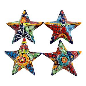 May include: Four ceramic star-shaped decorations with vibrant, hand-painted designs. Each star features a unique pattern of red, blue, green, and yellow, with intricate floral and geometric motifs. The stars are approximately 6 inches across.