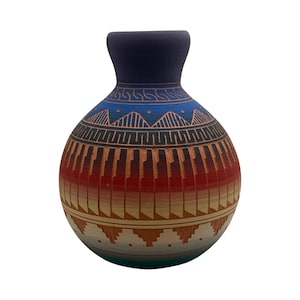 May include: A spherical ceramic vase with a narrow neck and a matte finish. The surface features a gradient of colors transitioning from dark blue at the top to red, orange, yellow, and light blue at the base, decorated with intricate geometric patterns.