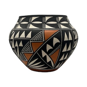 May include: A rounded ceramic pot featuring a matte finish with a geometric pattern in black, white, and terracotta orange. The design includes repeating triangles, lines, and curved shapes encircling the body and a wide, open top rim.