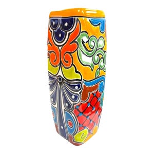 May include: A tall, hand-painted ceramic vase with a vibrant, colorful design. The vase features a mix of orange, yellow, blue, green, and red hues. The design includes floral and geometric patterns, making it a decorative piece.