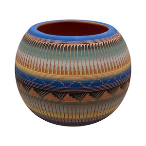 May include: A spherical clay pot featuring a wide blue rim and a body decorated with horizontal bands of etched vertical lines, geometric step patterns, and triangular motifs in shades of blue, green, yellow, and terracotta orange.