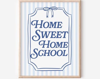Puede incluir: Un estampado enmarcado con la frase "Home Sweet Home School" en azul. El texto está dentro de una forma ornamentada con contorno azul, sobre un fondo a rayas azules y blancas. El marco es de color madera clara.