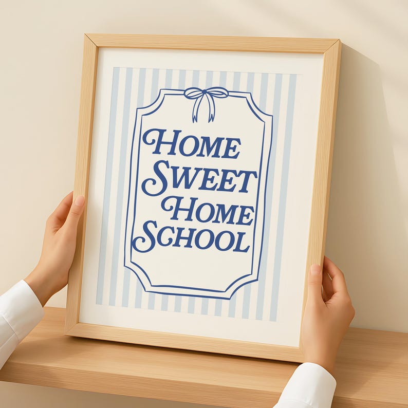 Pode incluir: Uma impress&atilde;o emoldurada com as palavras "Home Sweet Home School" em escrita azul marinho. O fundo apresenta listras verticais azuis claras. A moldura &eacute; de madeira clara.