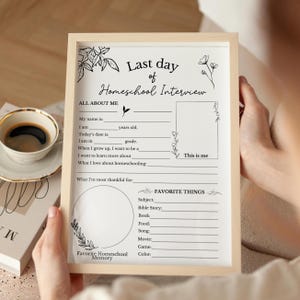 May include: A framed "Last Day of Homeschool Interview" printable. The beige frame holds a white sheet with fill-in-the-blank sections for personal details and favorite things. Floral illustrations and the words "This is me" are also included.