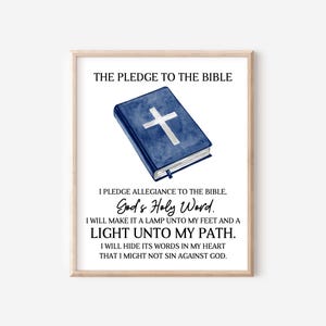 May include: A framed print with a blue watercolor illustration of a closed Bible with a white cross on the cover. The text reads "The Pledge to the Bible, God's Holy Word. I will make it a lamp unto my feet and a light unto my path. I will hide its words in my heart that I might not sin against God."
