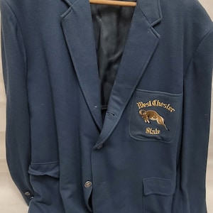 May include: A dark blue blazer with a patch on the pocket that says "West Chester State" and features a ram.