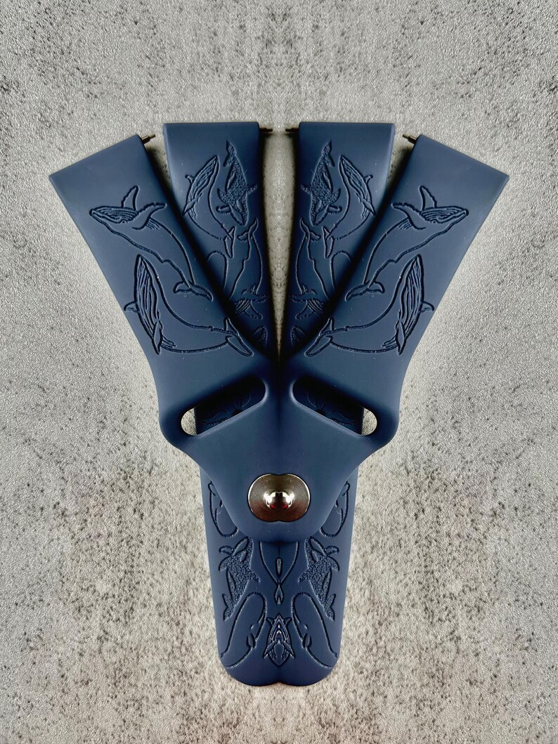 K&ouml;nnte beinhalten: Ein dunkelblaues Silikon-Armband mit einem Wal-Design. Das Armband hat eine Metallschlie&szlig;e und eine strukturierte Oberfl&auml;che.