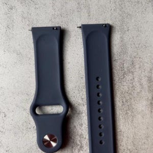 K&ouml;nnte beinhalten: Zwei dunkelblaue Silikon-Armb&auml;nder mit silbernen Metallschlie&szlig;en. Die Armb&auml;nder sind f&uuml;r Smartwatches konzipiert.