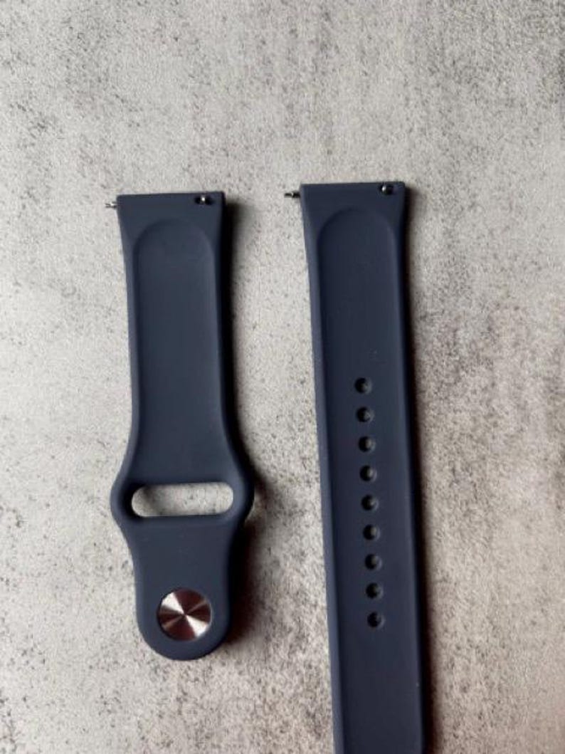 K&ouml;nnte beinhalten: Zwei dunkelblaue Silikon-Armb&auml;nder mit silbernen Metallschlie&szlig;en. Die Armb&auml;nder sind f&uuml;r Smartwatches konzipiert.