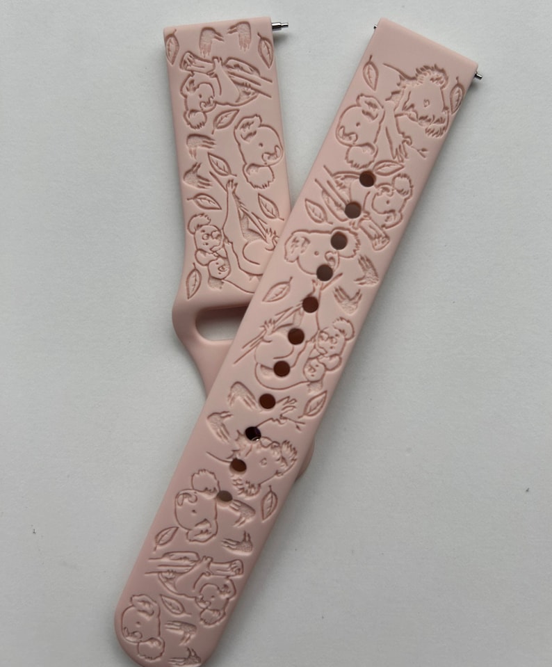 Puede incluir: Una correa de reloj de silicona rosa con un dise&ntilde;o de koala. La correa tiene un patr&oacute;n repetitivo de koalas sosteniendo hojas de eucalipto.